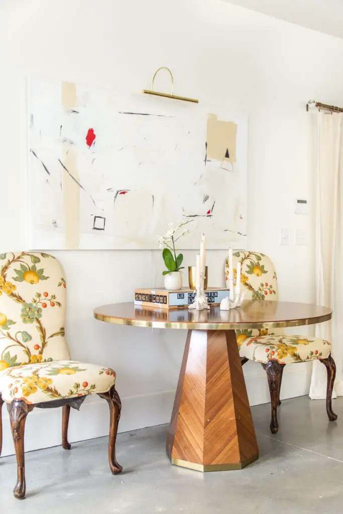 Round marquetry dining table from Anthropologie outlet in Georgia in apartment entryway with abstract painting and floral dining chairs by Kevin O'Gara on Thou Swell #entryway #diningtable #roundtable #marquetry #anthropologie #homedecor #interiordesign