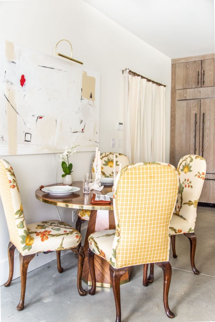 Round marquetry dining table from Anthropologie outlet in Georgia in apartment entryway with abstract painting and floral dining chairs by Kevin O'Gara on Thou Swell #entryway #diningtable #roundtable #marquetry #anthropologie #homedecor #interiordesign