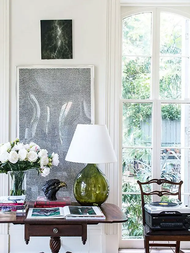 Console table with green glass cordless lamp and artwork in Sarah Ruffin Costello's New Orleans home on Thou Swell #tablelamp #cordlesslamp #consoletable #vignette #homedecor #homedesign #neworleans
