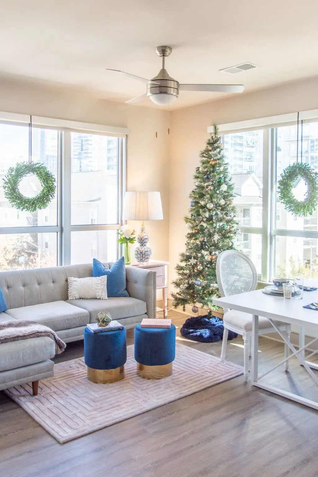 Apartment living room Christmas tree holiday decor with pink and blue, maze rug, velvet stools, and tan sectional by Kevin O'Gara on Thou Swell #apartmentstyle #apartmentdesign #apartmentdecor #livingroom #livingroomdesign #livingroomdecor #christmastree #holidaydecor #christmastyle #homedecorideas