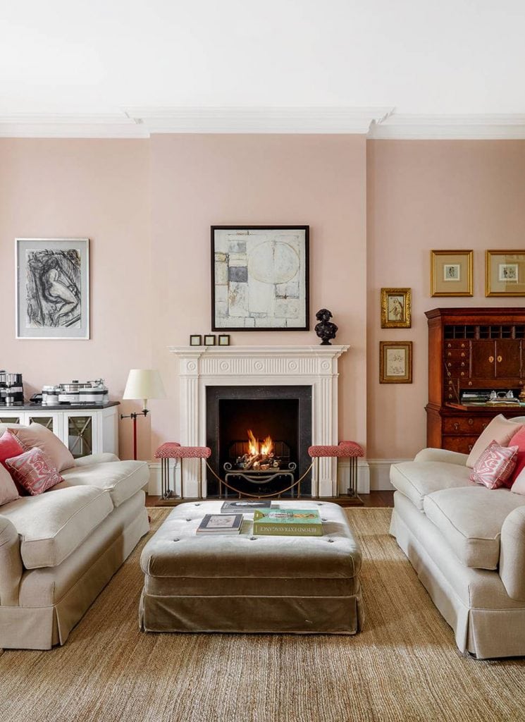 Pink London living room design with blush pink walls, tan sofas facing each other by fireplace on Thou Swell #pinkroom #pinkwalls #livingroom #livingroomdesign #pinkpaint #homedecor #homedecorideas