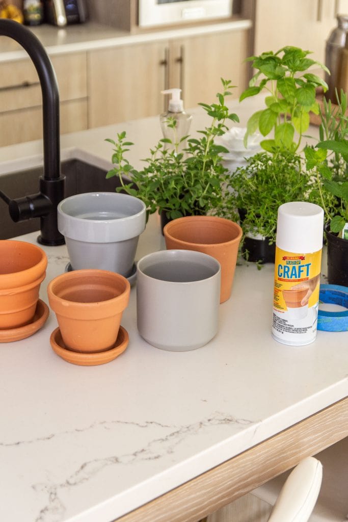 Indoor countertop herb garden in the kitchen with mismatched pots and Plasti Dip Craft coating DIY project on Thou Swell #herbgarden #indoorplants #indoorgarden #kitchengarden #plastidip 