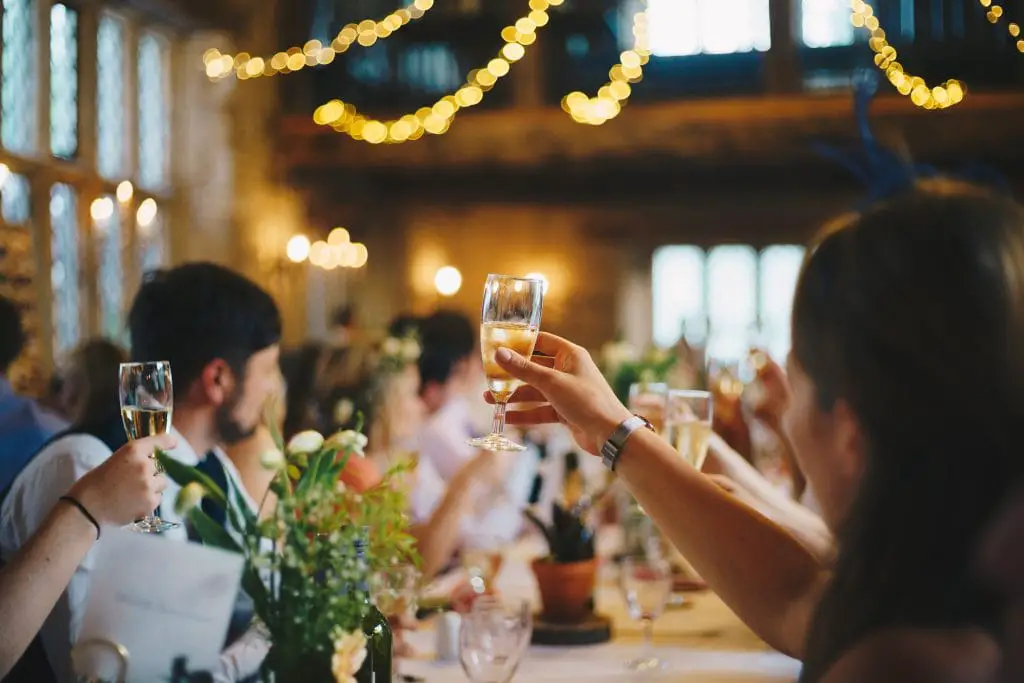 People sitting at a table raising their glasses in a toast