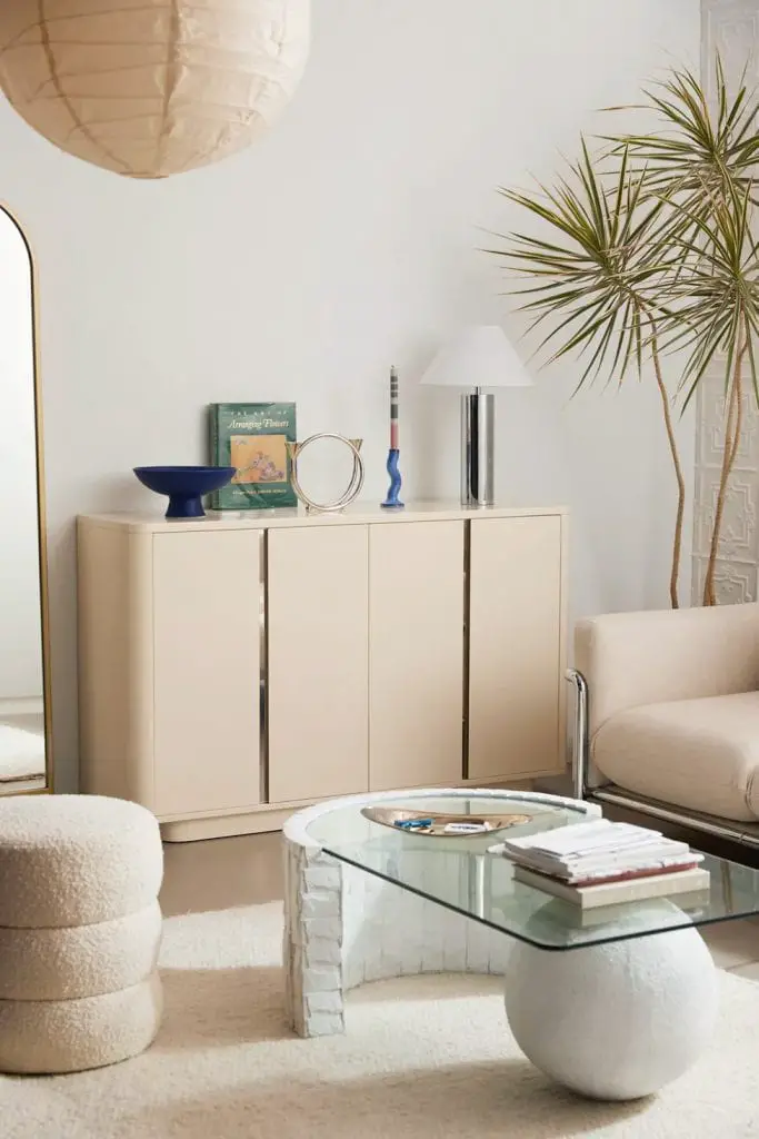 Pied-a-terre furniture collection by Urban Outfitters home with beige lacquered cabinet and modern sculpture coffee table on Thou Swell 